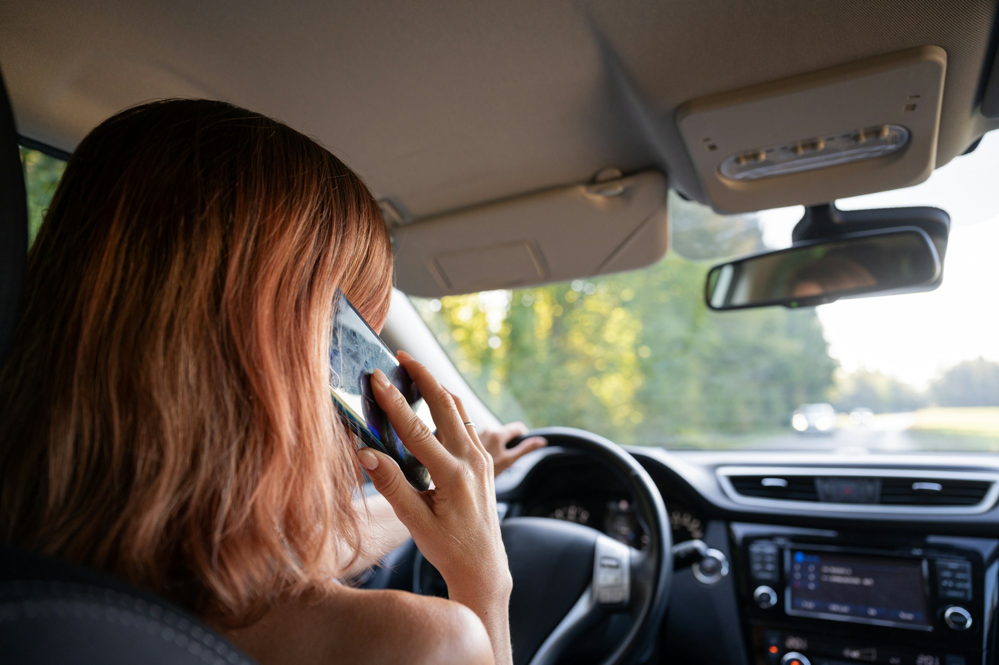 Woman using mobile phone while driving